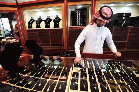 بائع سعودي يعدل قلادات الماس في محل مجوهرات في سوق طيبة (أ ف ب)