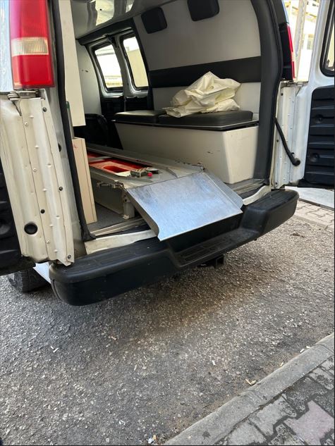 سيارة الإسعاف تنقل جثمانين من براد مستشفى رفيق الحريري الحكومي.