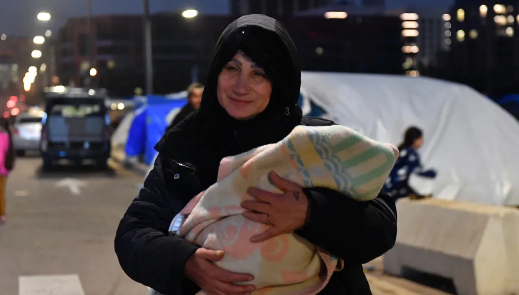 Woman carrying her child outside a displacement center in Beirut.