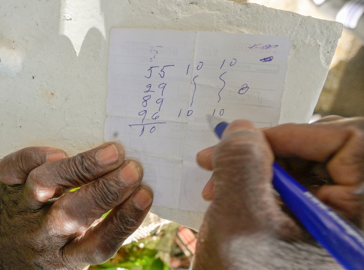 رجل يكتب على وصفة طبية المال الذي سيلعب به في يانصيب 