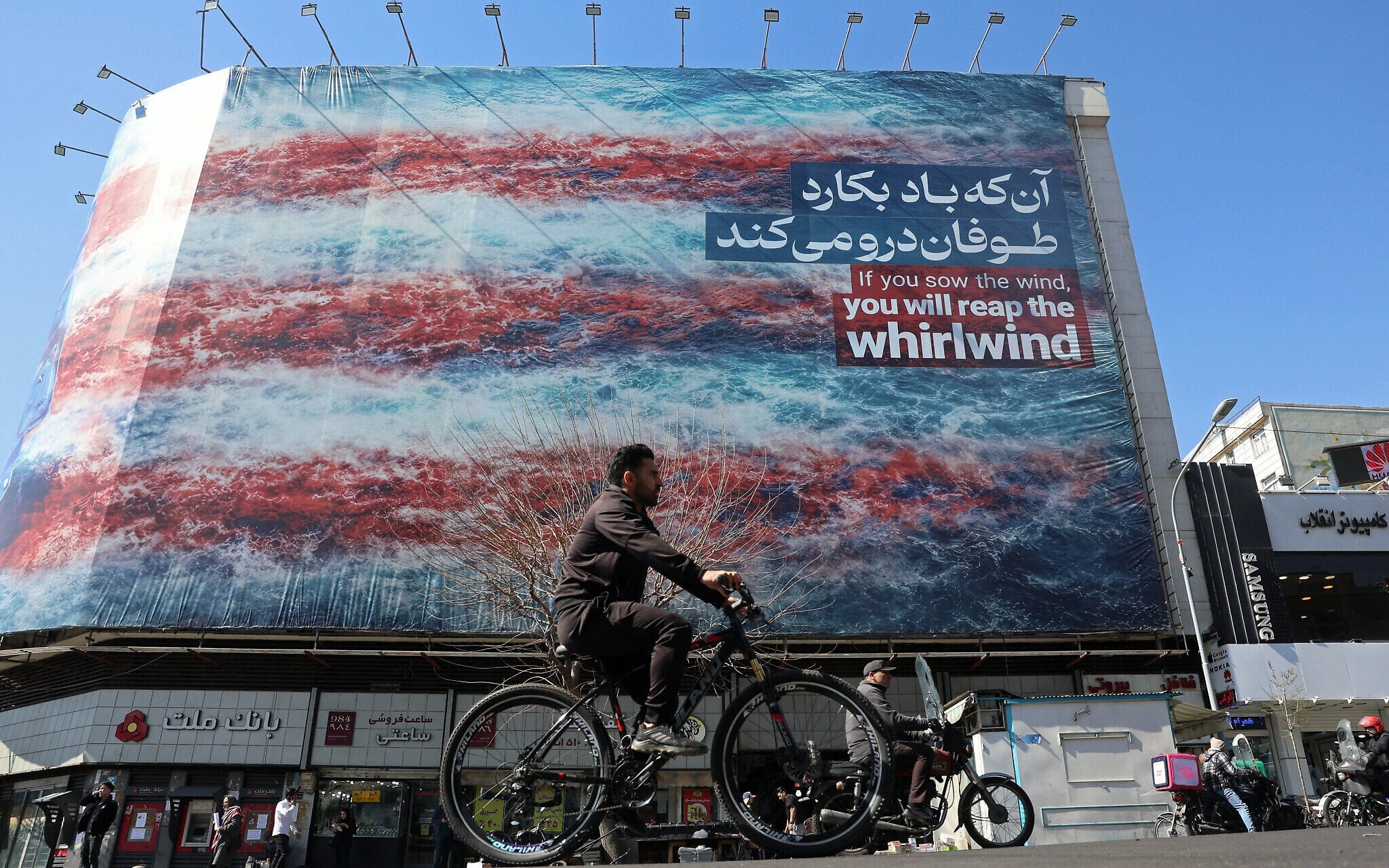 دراج يمر بلوحة جدارية مناهضة للولايات المتحدة في طهران، إيران، 26 فبراير 2026. (فرانس برس)