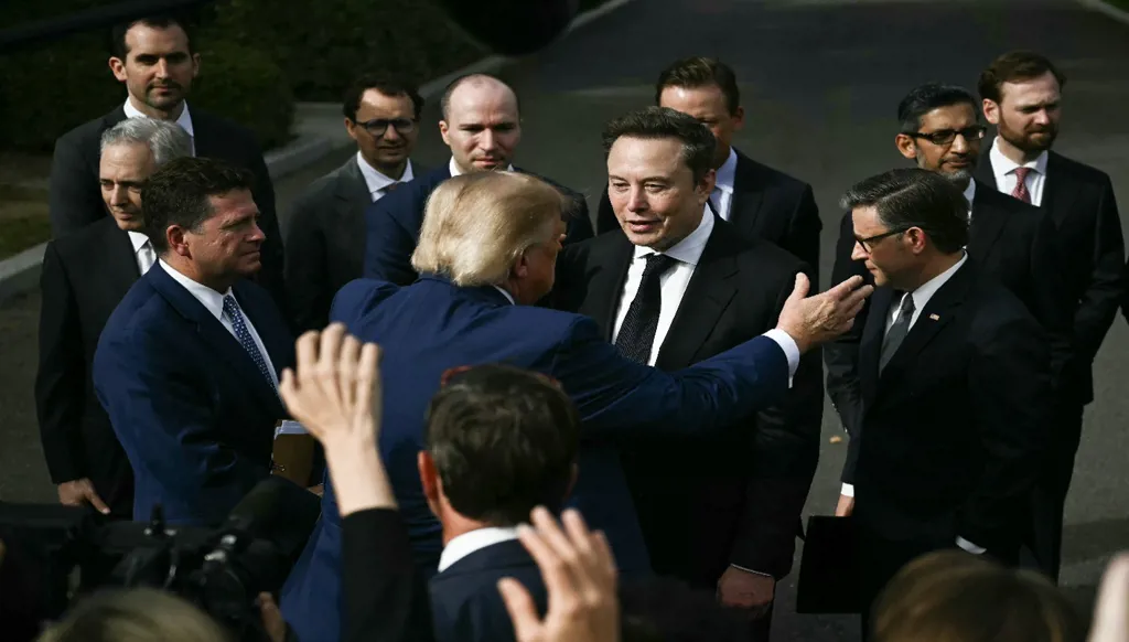 دونالد ترامب مستقبلاً إيلون ماسك بعد اجتماع مع مسؤولين تنفيذيين في مجال التكنولوجيا حول الذكاء الاصطناعي (أ ف ب)