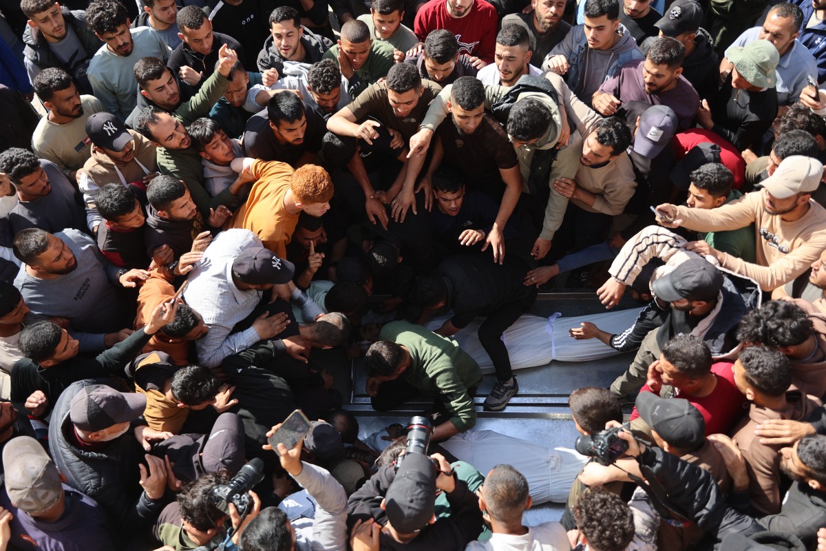 فلسطينيون نازحون يتجمعون حول جثث أربعة أشخاص قُتلوا في غارة إسرائيلية استهدفت مركبة في مدينة غزة، في 28 نيسان/أبريل 2026 (أ ف ب)