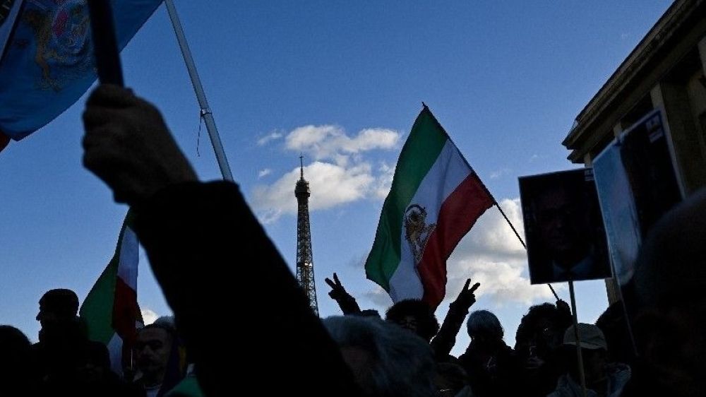 علم إيران ما قبل الثورة مرفوعاً في إحدة التظاهرات. (أ ف ب)