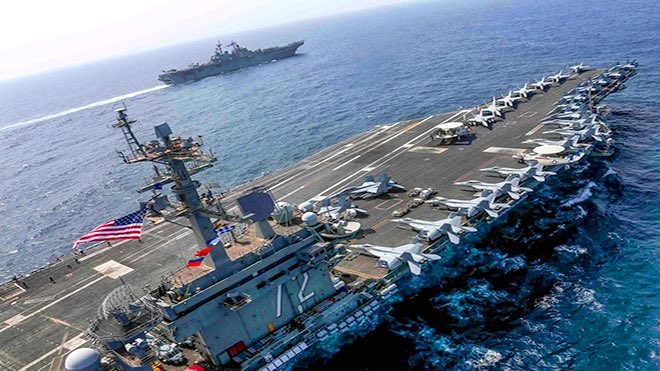 حاملة الطائرات أبراهام لينكولن وسفينة هجومية تبحران في بحر العرب. (رويترز)