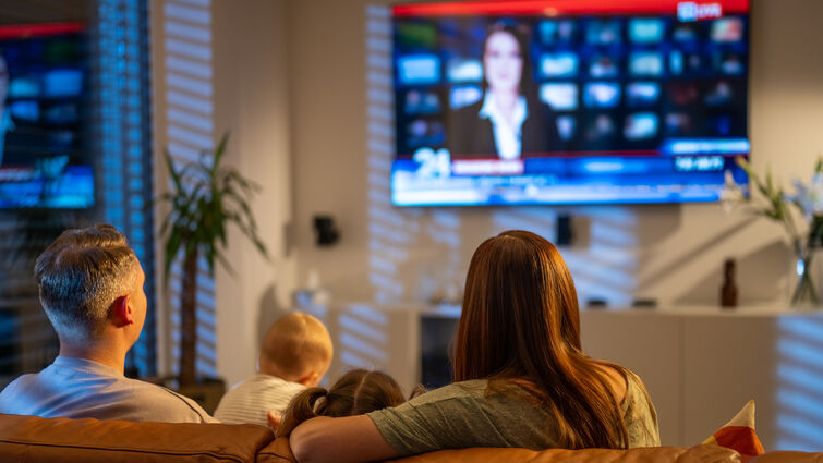 طفل يشاهد أخبار مع أهله (getty)