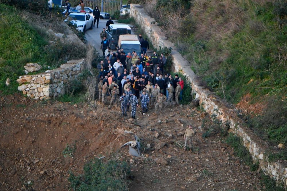 مواطنون وعناصر أمنية أمام الحفرة التي أحدثتها الغارة الإسرائيلية في منطقة مار روكز القريبة من المنصورية أمس. (حسام شبارو)