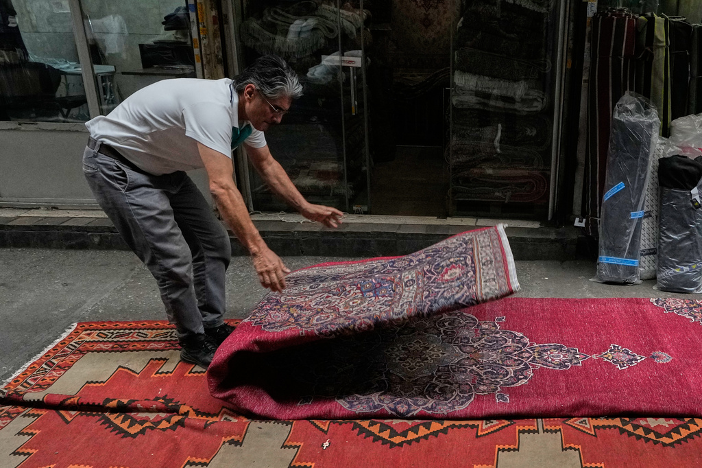 رجل يطوي سجادة في بازار طهران الكبير، 25 آب/أغسطس 2026. (أ ب)