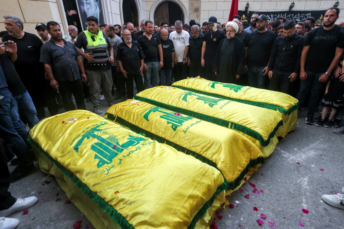 جثامين أربع نساء ملفوفة بعلم حزب الله، واللاتي قُتلن في اليوم السابق إثر قصف إسرائيلي على قرية قناريت، جنوب صيدا، خلال الجنازة في 21 يونيو 2026 (أ ف ب)