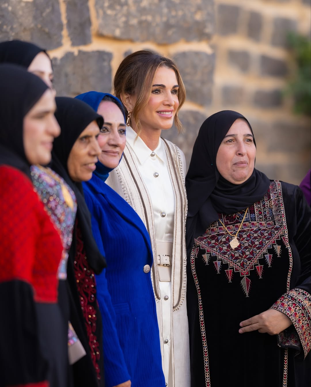 الملكة رانيا بعباءة بيضاء في لقاء سيدات المفرق في بلدة أم الجمال (انستغرام)