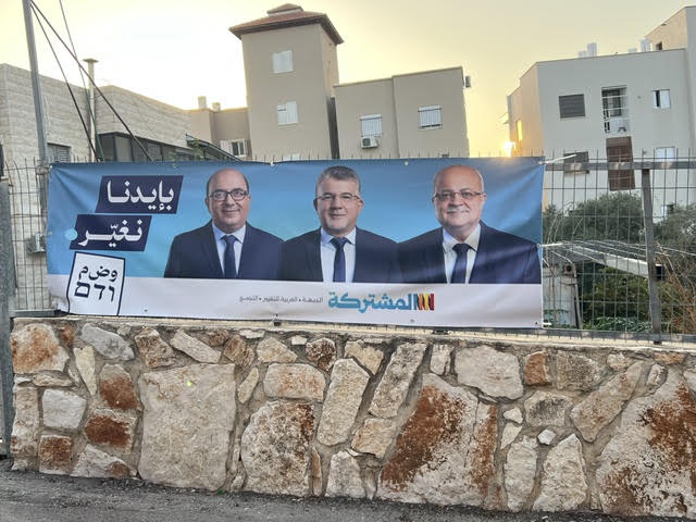 لافتة انتخابية للقائمة المشتركة تحمل شعار بإيدنا نغيّر، في كفر ياسيف، استعداداً لانتخابات الكنيست الإسرائيلية. (النهار)