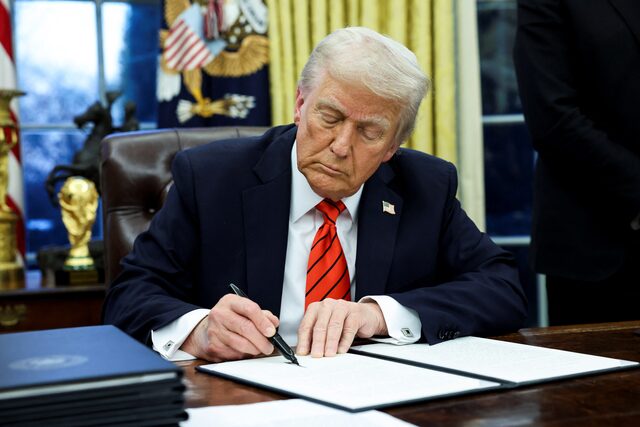 الرئيس الأميركي دونالد ترامب يوقِّع على أمر تنفيذي في البيت الأبيض (رويترز)