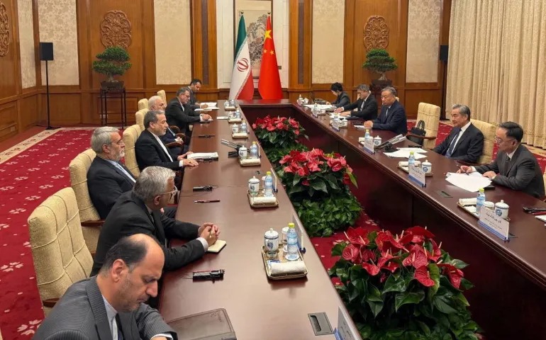 الوفدان الإيراني والصيني خلال اللقاء في بكين (رويترز)