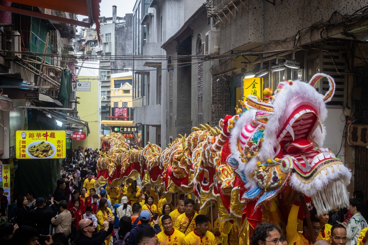 يشارك مؤدّون في رقصة تنين في أحد الشوارع خلال احتفالات اليوم الأول من السنة القمرية الجديدة، في ماكاو في 17 شباط/فبراير 2026 (أ.ف.ب)
