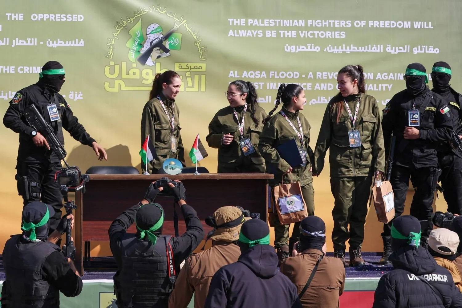 مقاتلو حماس مع 4 رهينات إسرائيليات قبل تسليمهن إلى فريق من الصليب الأحمر بمدينة غزة (أ.ف.ب)