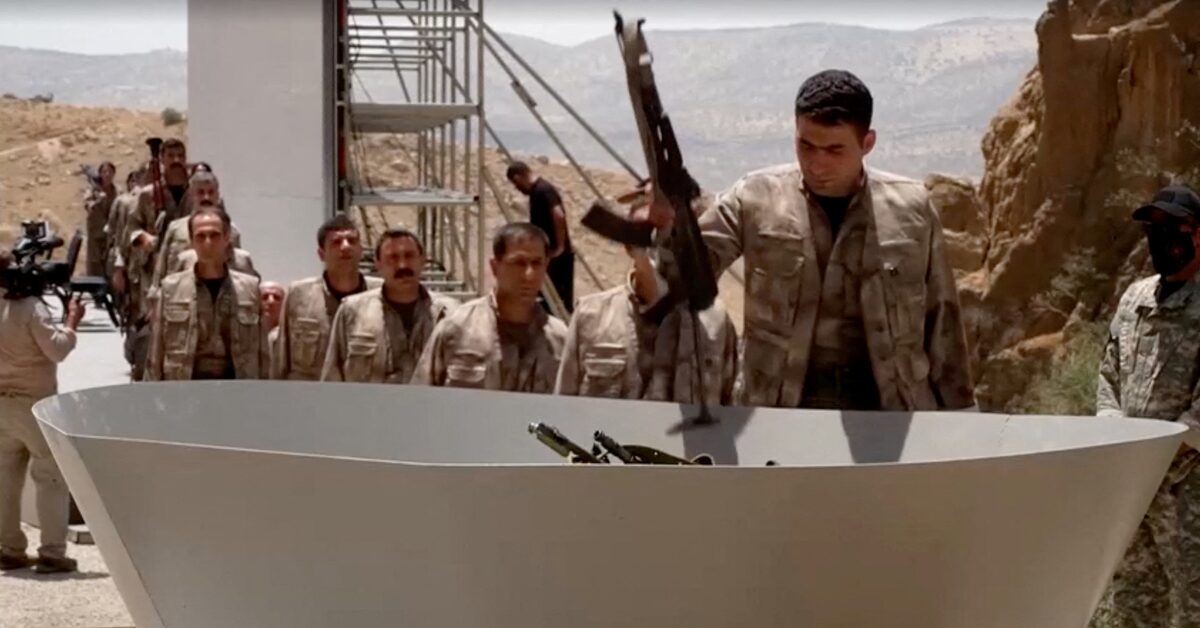 مقاتلون من حزب العمال الكردستاني يلقون أسلحتهم ليتم حرقها خلال مراسم نزع السلاح في السليمانية بالعراق يوم 11 يوليو تموز 2025 (رويترز)