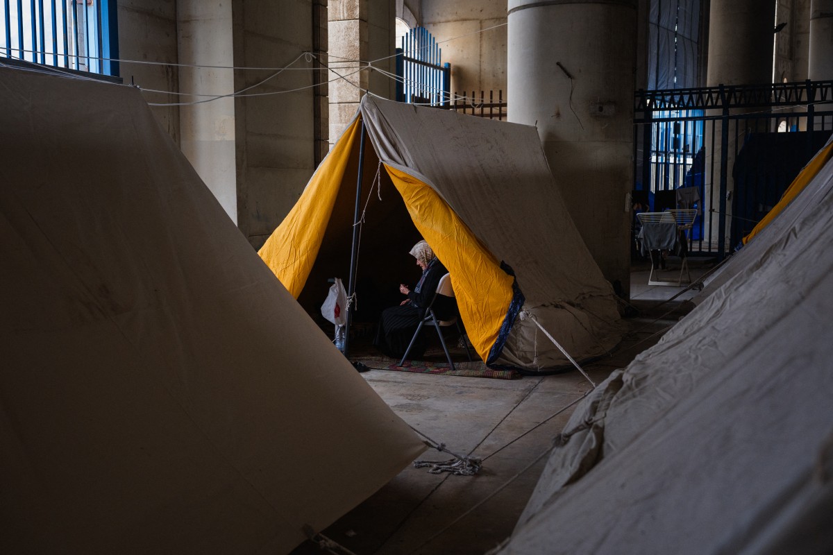 امرأة مسنة نازحة تجلس في خيمتها داخل ملعب مدينة كميل شمعون الرياضية في بيروت (أ ف ب)