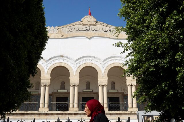 امرأة تسير بالقرب من قصر العدل في تونس العاصمة (رويترز)