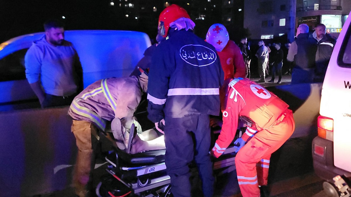 مسعفون يقومون بإجلاء ضحية من موقع استهدفت فيه غارة جوية إسرائيلية سيارة في منطقة خلدة جنوب بيروت، في 1 نيسان/أبريل 2026 (أ ف ب)