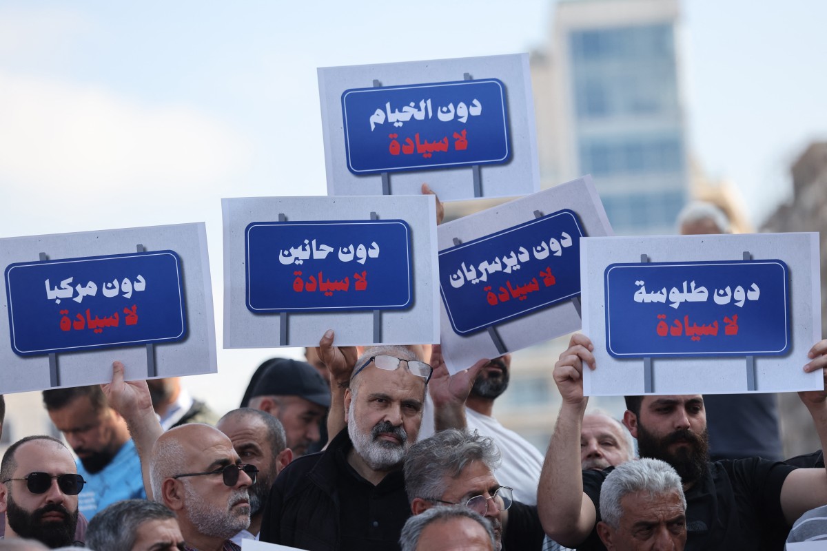 متظاهرون في وسط بيروت يرفعون لافتات تحمل أسماء قراهم الحدودية المدمرة، احتجاجاً على تدمير قراهم ومنعهم من العودة، في 30 نيسان/أبريل 2026 (أ ف ب)