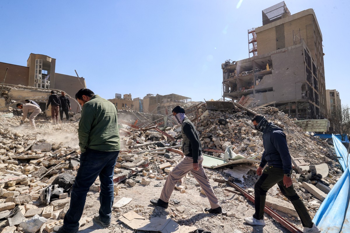 مواطنون إيرانيون يتفقدون أنقاض مبنى منهار بالقرب من ميدان فردوسي في طهران في 3 آذار/مارس 2026 (أ ف ب)