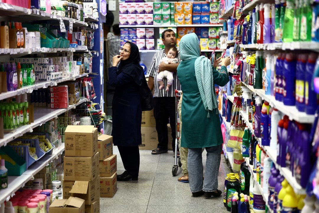 مواطنون إيرانيون يتسوقون في متجر في طهران (رويترز)
