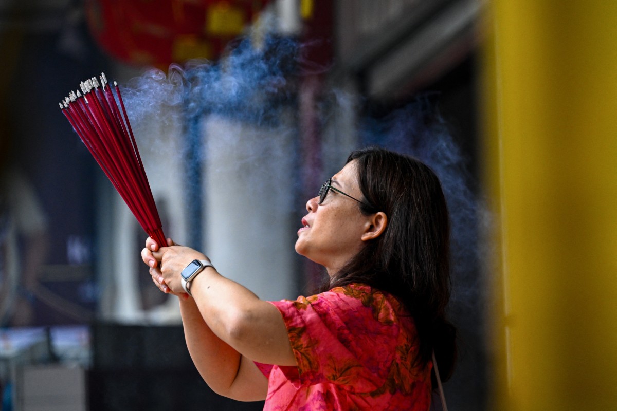 امرأة البخور تحرق أثناء صلاتها في أحد المعابد في اليوم الأول من عام الحصان، في إندونيسيا، في 17 شباط/فبراير 2026 (أ.ف.ب)