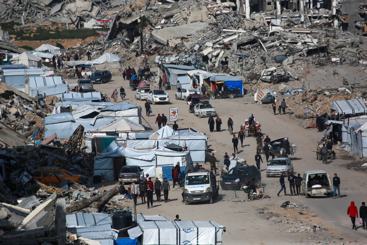 فلسطينيون بين المنازل المدمرة في غزة (أ ف ب)