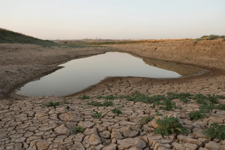 أرض متشققة على ضفاف نهر الخابور بفعل الجفاف شرقي سوريا (رويترز)