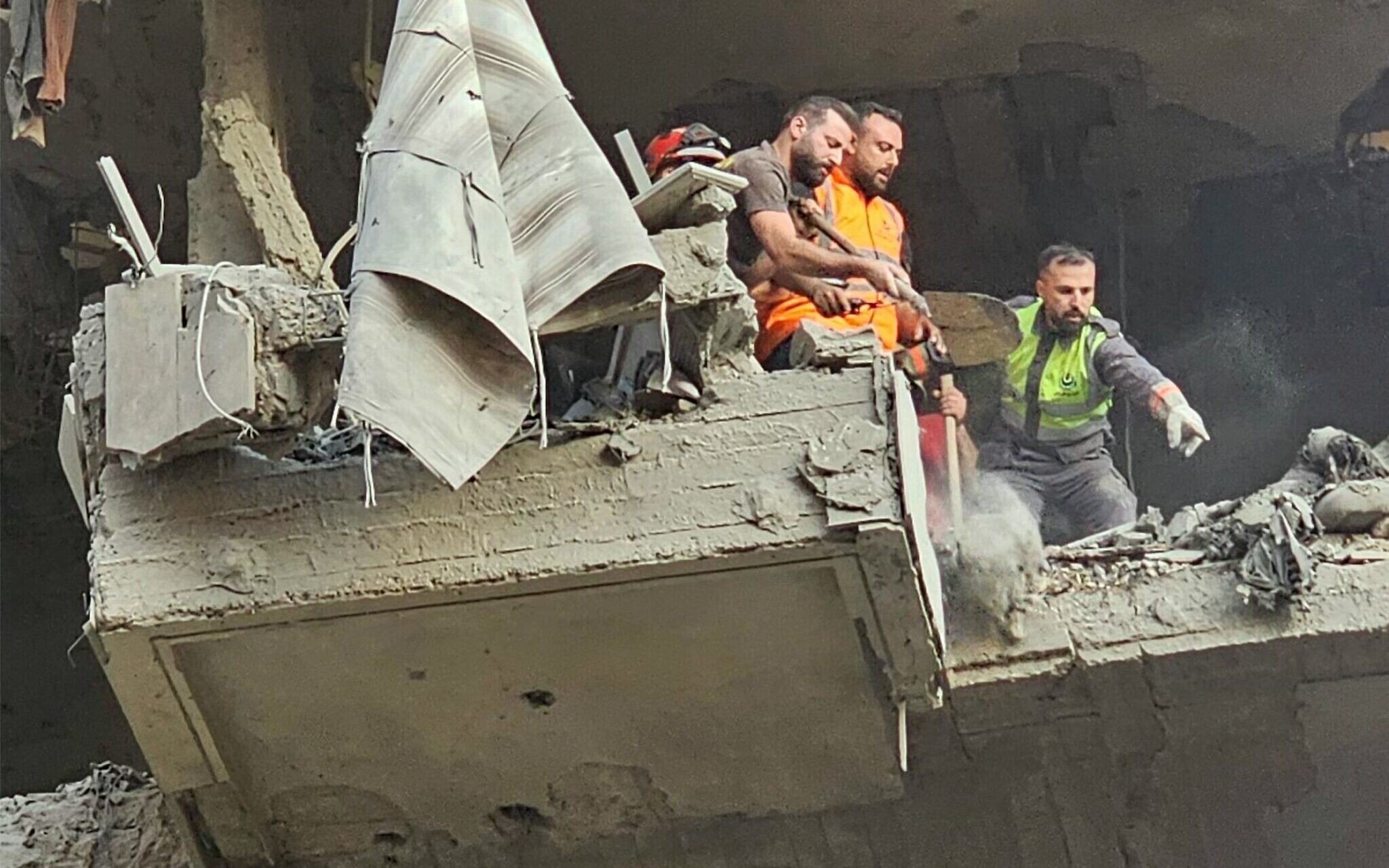 رجال الإنقاذ يبحثون عن ناجين في موقع غارة إسرائيلية على مبنى سكني في الضاحية الجنوبية لبيروت، 23 نوفمبر 2025. (أ ف ب)