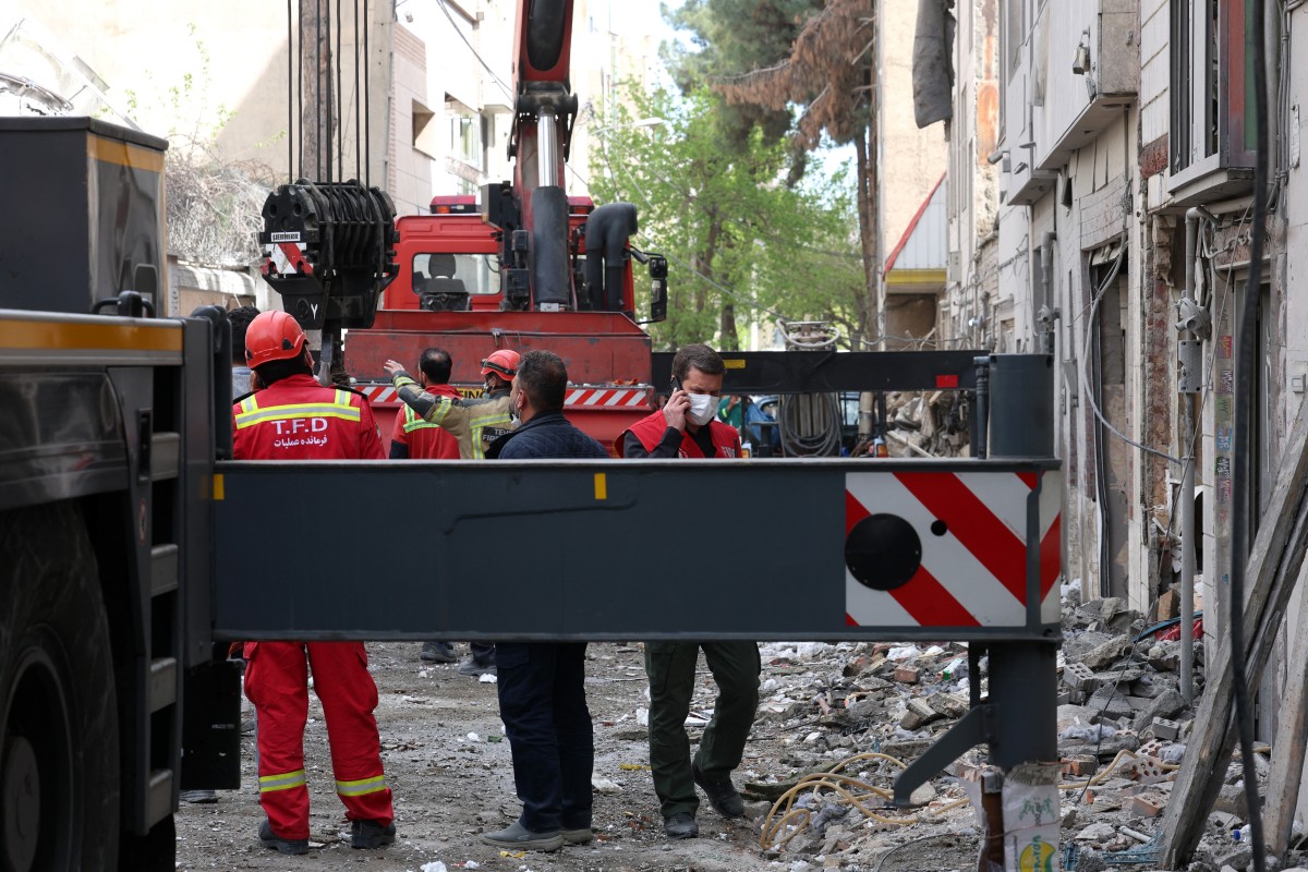 رجال إطفاء يبحثون عن ضحايا ويتفقدون الأضرار في مبنى سكني جنوب طهران في 27 آذار مارس 2026 (أ ف ب)