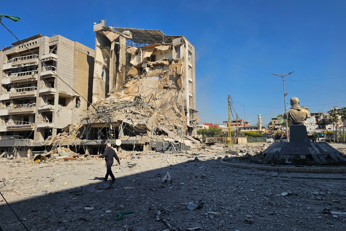 رجل يمر بجوار مبنى مدمر في أعقاب غارة جوية إسرائيلية استهدفت طريق المطار الذي يمر عبر الضواحي الجنوبية لبيروت في 9 آذار/مارس 2026 (أ ف ب)