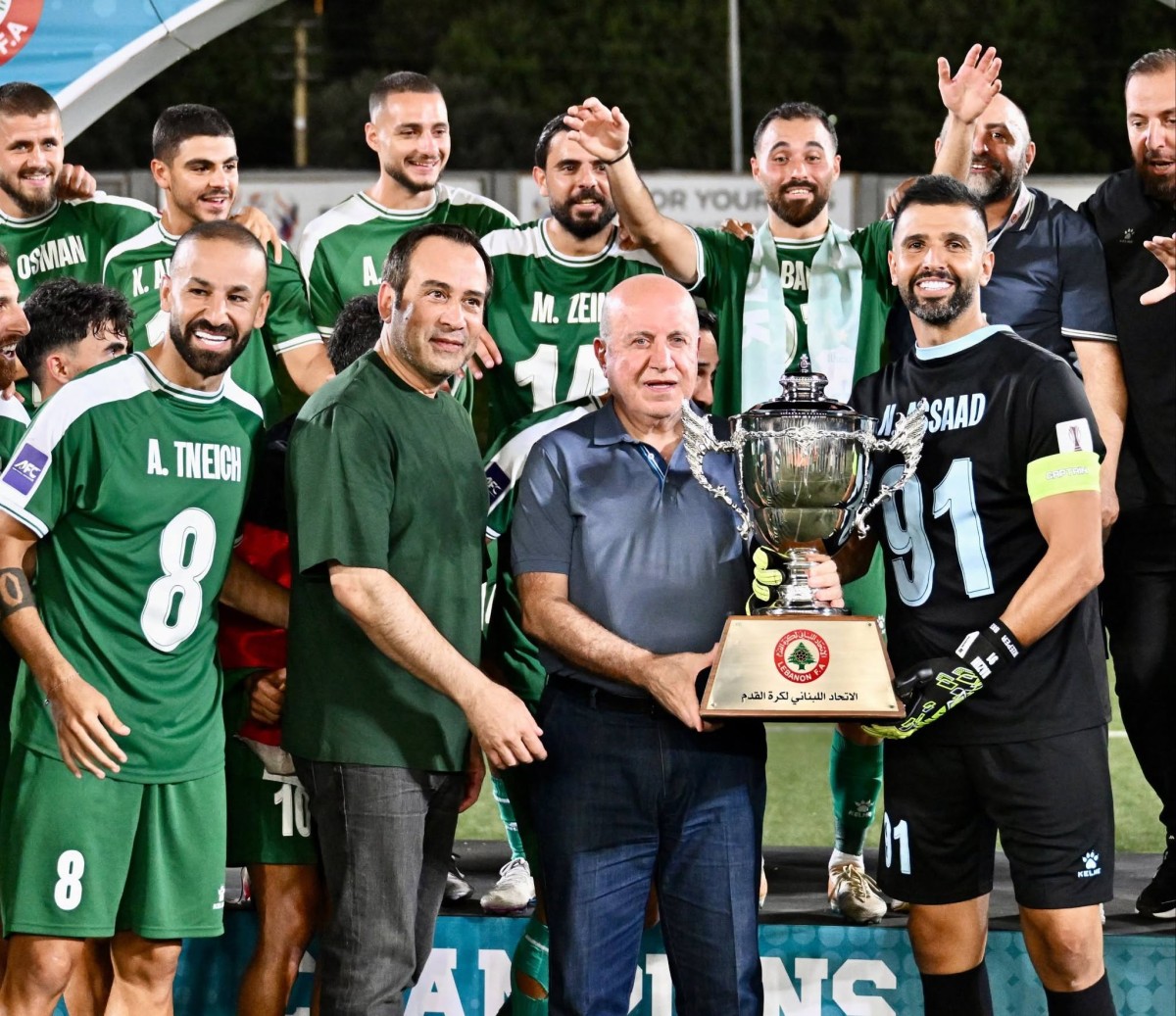 رئيس الاتحاد اللبناني هاشم حيدر يسلم كأس البطولة لقائد الأنصار نزيه أسعد بحضور رئيس النادي النائب نبيل بدر. (طلال سلمان)