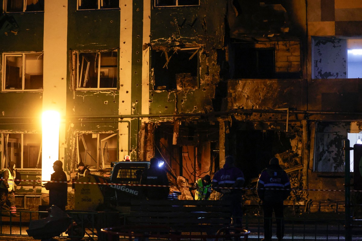 عمال يزيلون الأنقاض من مبنى سكني متضرر إثر هجوم بمسيرة في أوكرانيا (أ ف ب)