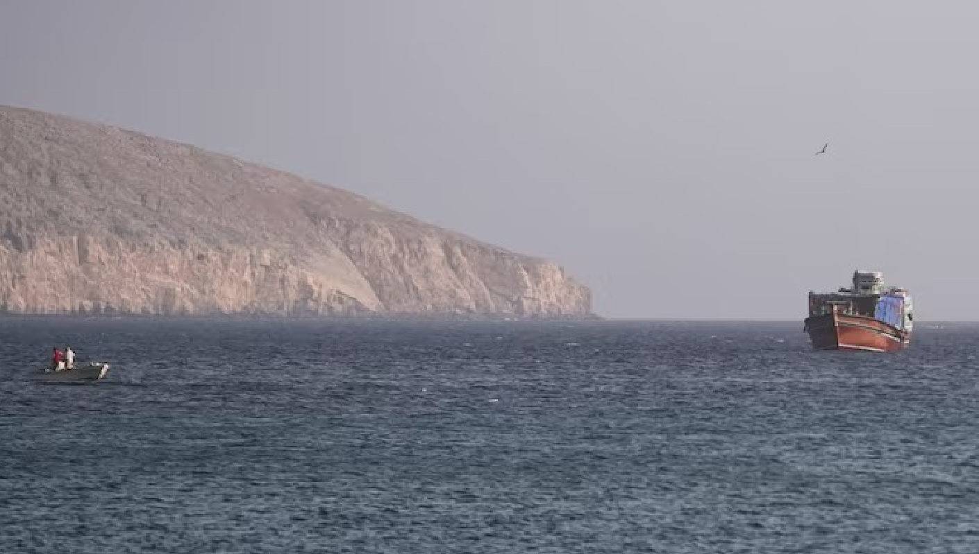 سفينة في مضيق هرمز، كما تُرى من مسندم بعُمان (رويترز)