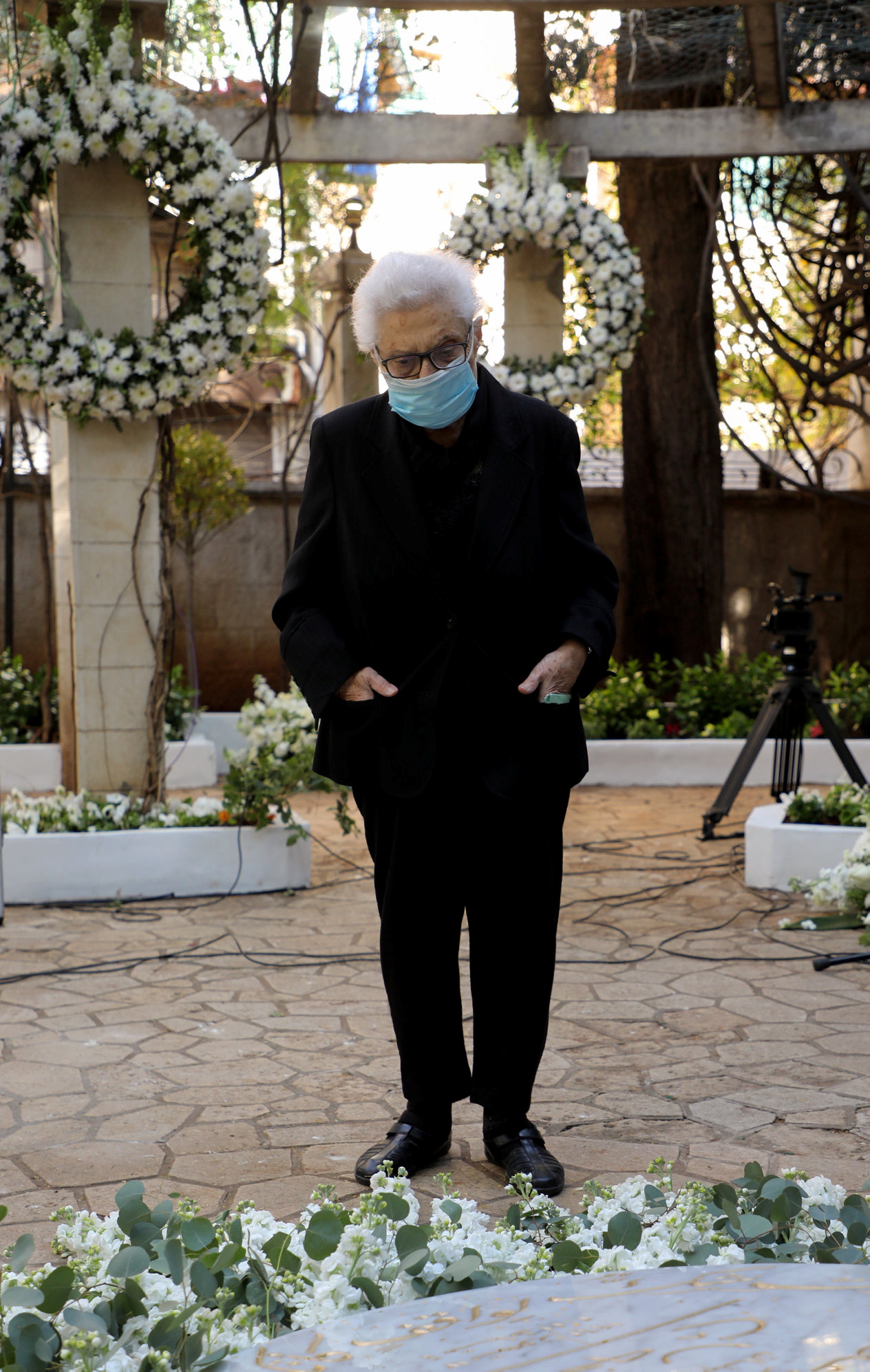 سلمى مرشاق أمام ضريح ابنها لقمان سليم في دارة العائلة في الغبيري (رويترز)