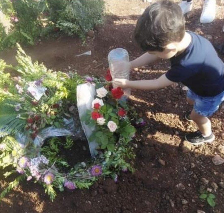 طفل إحدى ضحيتي طاقم السفينة يضع زهوراً في موقع سقوط والده.