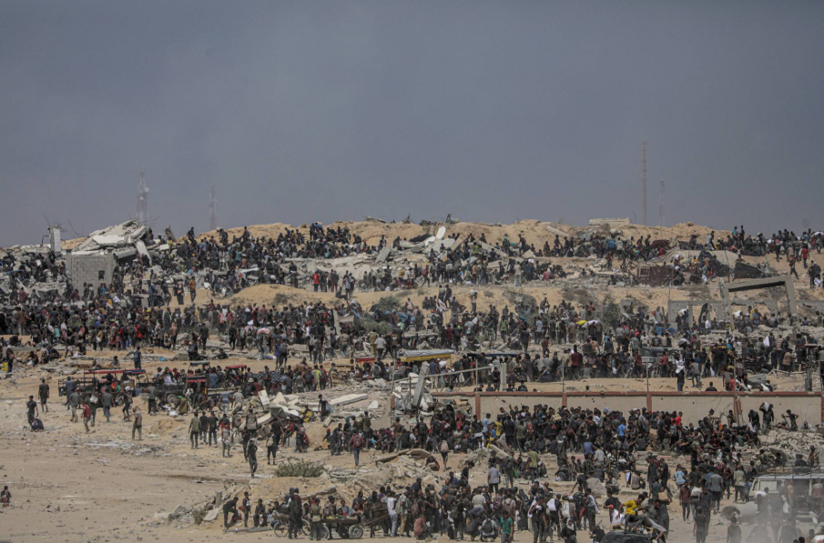 نازحون فلسطينيون ينتظرون شاحنات مساعدات قرب نقطة توزيع أغذية في زيكيم شمال قطاع غزة (إ.ب.أ)