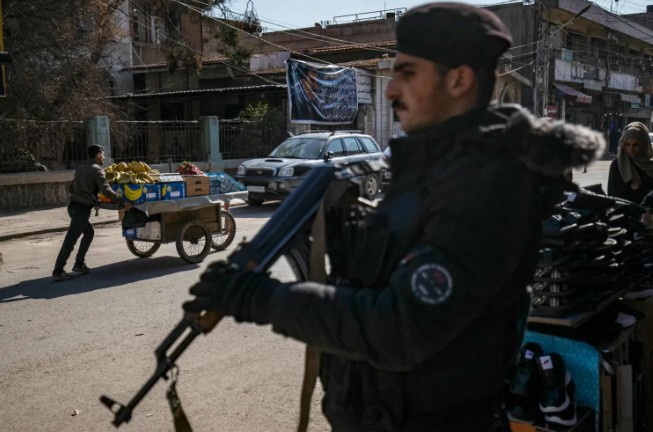 أحد عناصر قسد خلال نوبة حراسة في شوارع القامشلي شمال شرقي سوريا (أ ف ب)