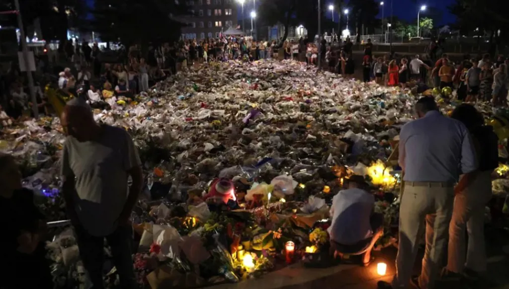 يتجمع المشيعون بجانب الزهور الموضوعة تكريماً لضحايا حادث إطلاق النار في شاطئ بوندي، في سيدني في 20 ديسمبر 2025. (أ ف ب)