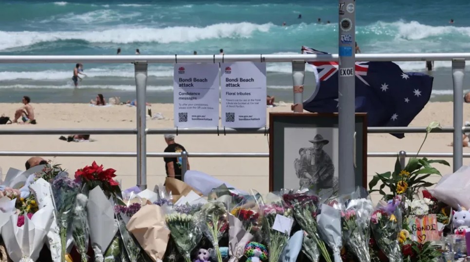 زهور تذكارية تركها المعزون على ممشى شاطئ بوندي في سيدني، (أ ف ب).