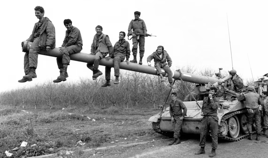 Israeli soldiers sitting on the barrel of a tank during the 1982 war. Photo: Alain Mingam / Gamma-Rapho / Getty Images.