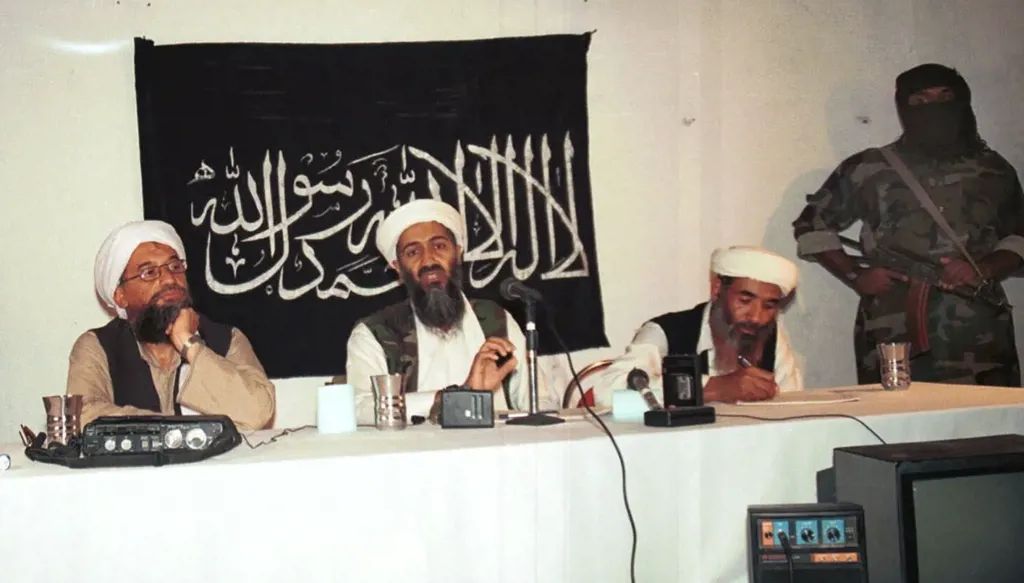 صورة من عام 1998 تُظهر أسامة بن لادن محاطا بمساعديه وحراسه المسلحين خلال اجتماع في مكان لم يُكشف عنه في أفغانستان, (أ ب).
