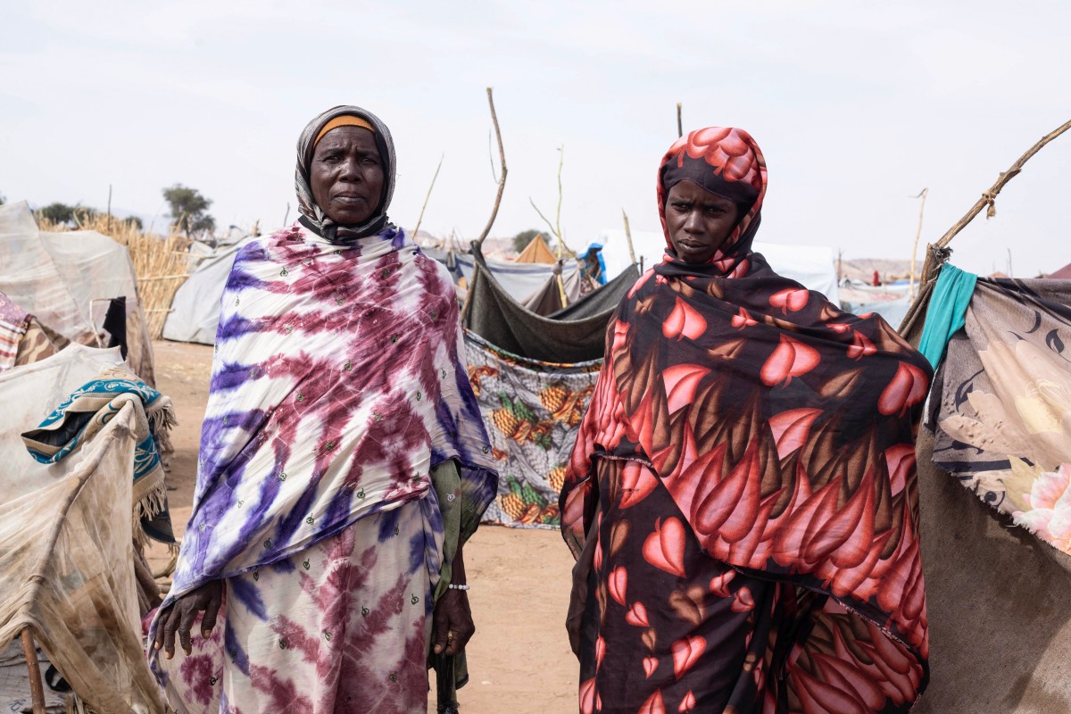 نازحتان سودانيتان من الفاشر في مخيم على الحافة الجنوبية الغربية لطويلة بإقليم دارفور (أ ف ب)