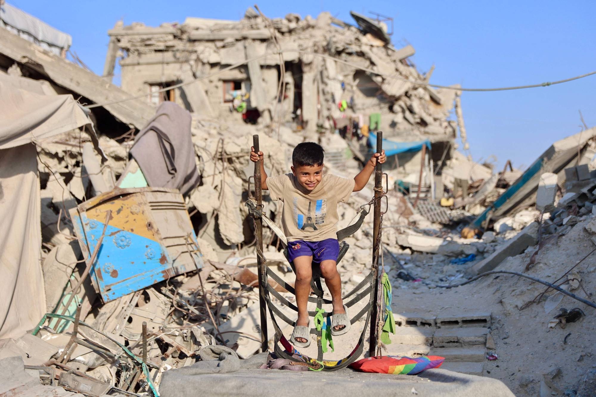 طفل فلسطيني يلعب بين أنقاض مبنى مدمّر في مخيم جباليا شمال قطاع غزة في 2 أغسطس الحالي (أ.ف.ب)