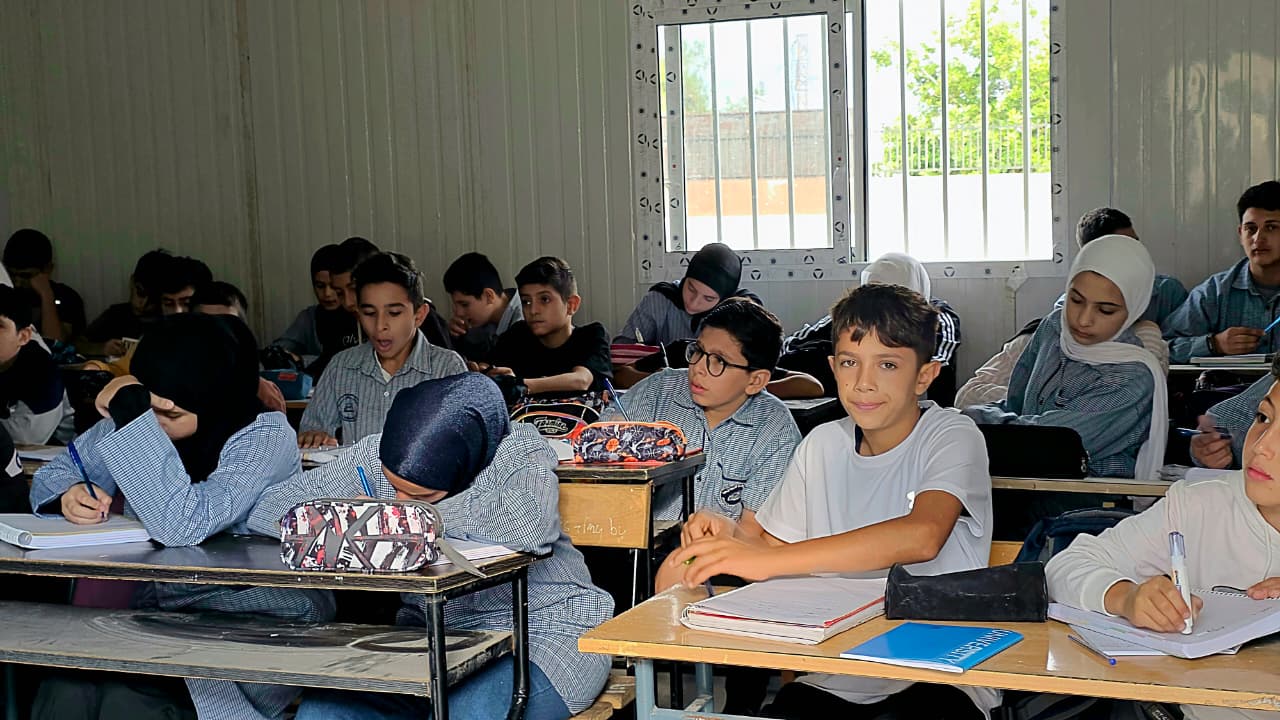 طلاب على مقاعد دراسية في غرفة جاهزة (أحمد منتش)