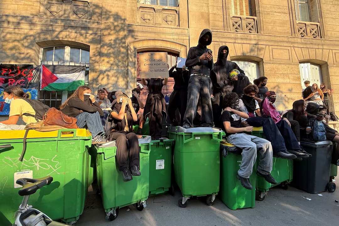 طلاب مدرسة ثانوية فرنسية يغلقون الطريق المؤدي إلى مدرسة ليسيه أراغو الثانوية في باريس (رويترز)