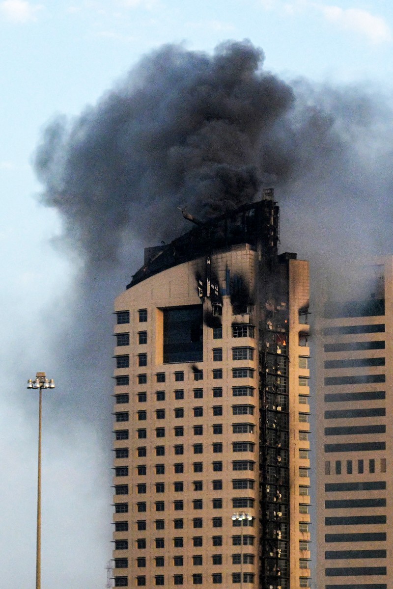 تصاعد الدخان من مبنى شاهق عقب هجوم بطائرة مسيّرة إيرانية في مدينة الكويت في 8 آذار/مارس 2026 (أ ف ب)