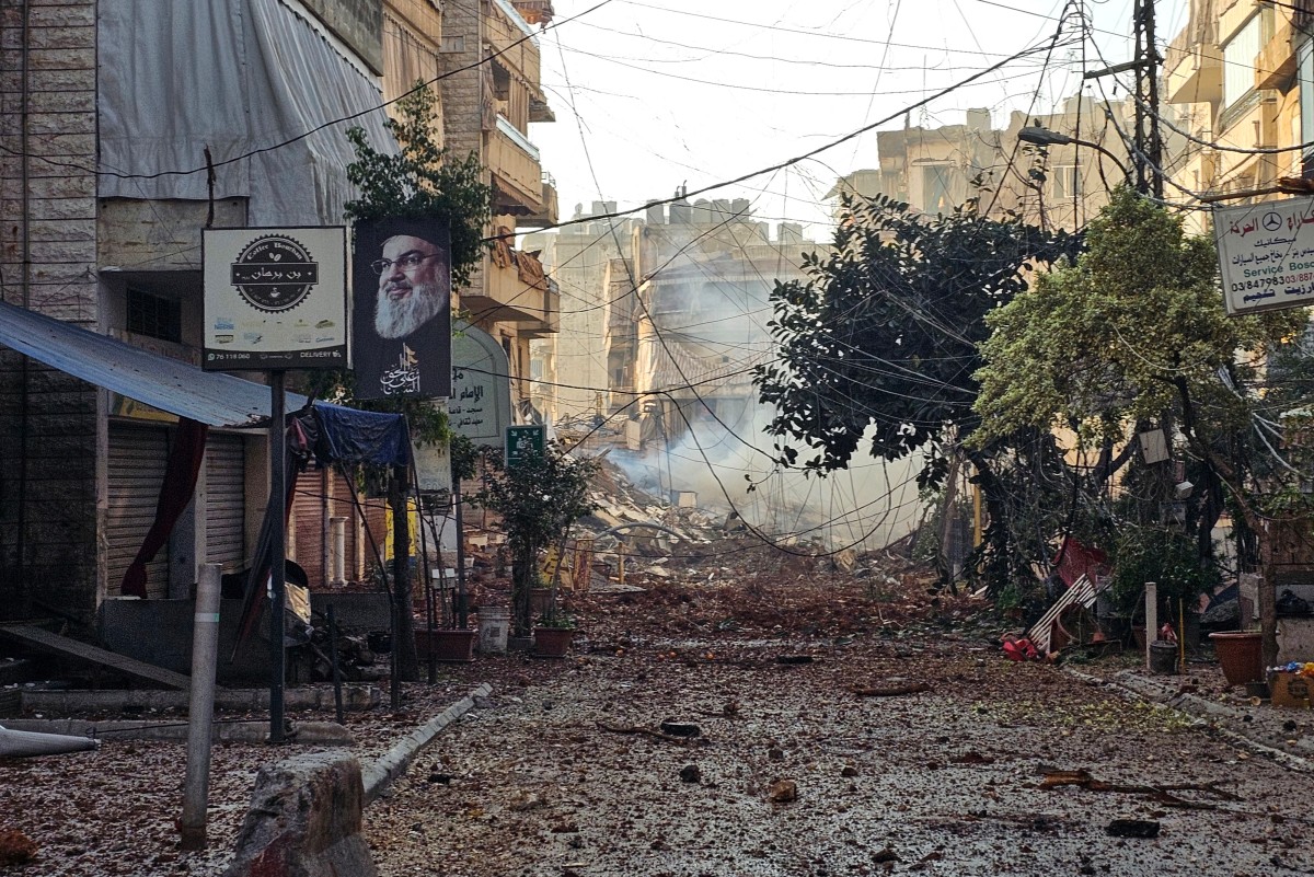 تتناثر الأنقاض في أحد الشوارع بينما يتصاعد الدخان من موقع غارة جوية إسرائيلية استهدفت حارة حريك في الضاحية الجنوبية لبيروت في 10 آذار/مارس 2026 (أ ف ب)