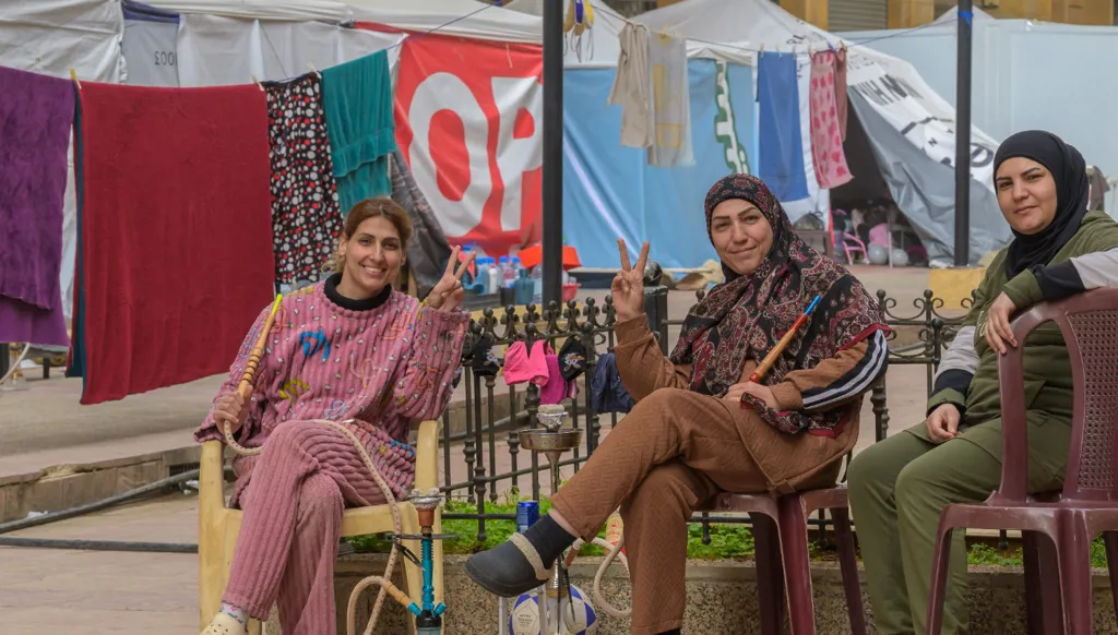 Three displaced women sitting in a Beirut displacement center.